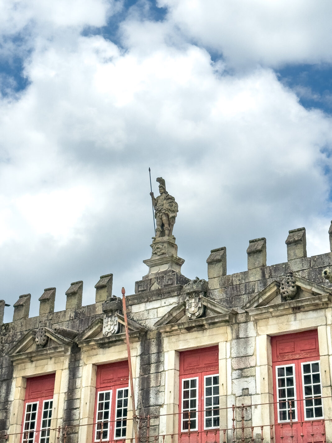 Foto: Wächter über Guimarães. Man sieht den oberen Teil des alten Rathauses der Stadt. Oben drauf steht eine Figur, die den Platz überblickt und das Gebäude bewacht.