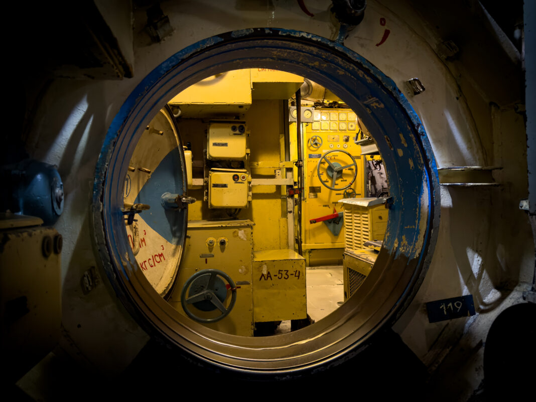 Foto: Durchgang im Uboot. Blick durch eine geöffnete Durchgangsluke in einem Uboot.